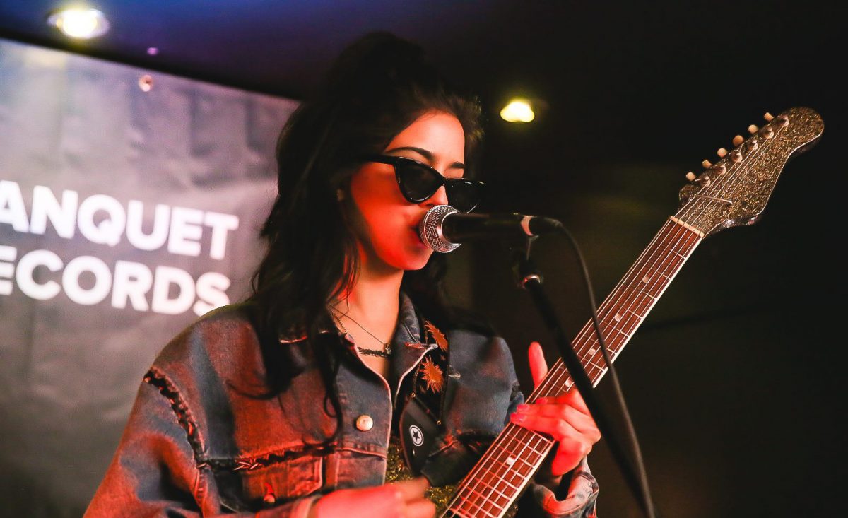 Miss World on stage playing guitar and singing at Banquet Records