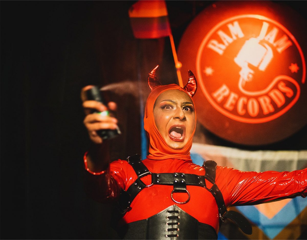 A drag queen in a devil costume on stage at Ram Jam Records