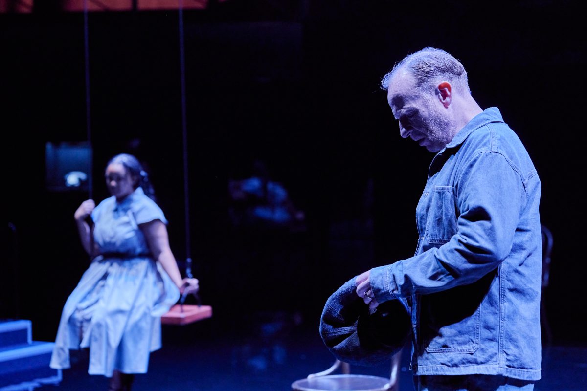 A still from the play showing Eddie looking forlorn in the forefront, with Catherine out of focus in the background. 