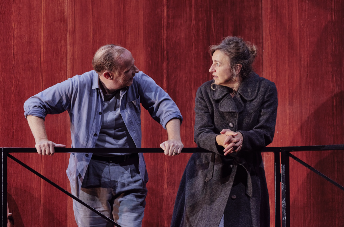 Still from A View From The Bridge of Eddie and Beatrice talking over a rail.