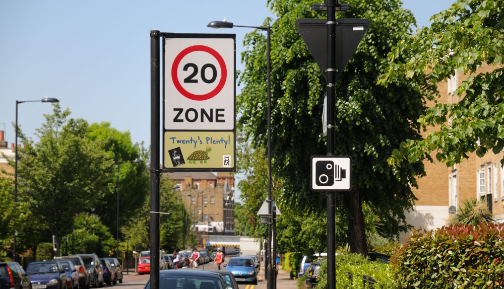 Twenty's plenty 20 Miles per hour speed limit sign in a built up residential area and a safety camera warning road sign Various London Stock - 24 May 2009
