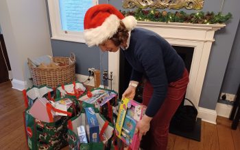 Woman wearing a Santa's hat, receives Christmas presents
