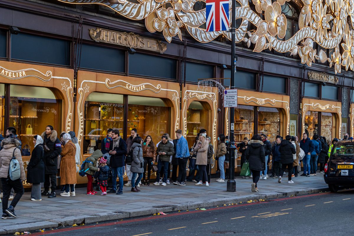 A line of people queuing in front of Harrods department store during the Christmas period. 