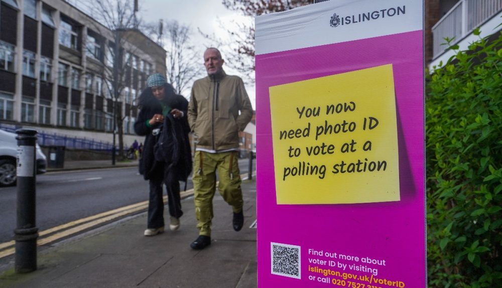 Sign telling people to bring photo ID to vote at a polling station.