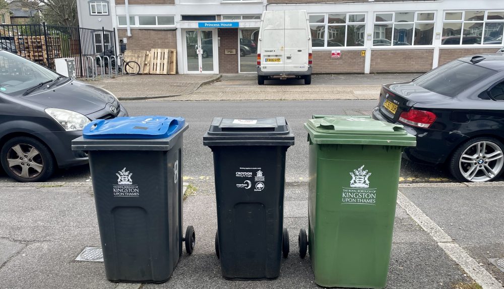 Three bins in row on the side of a road