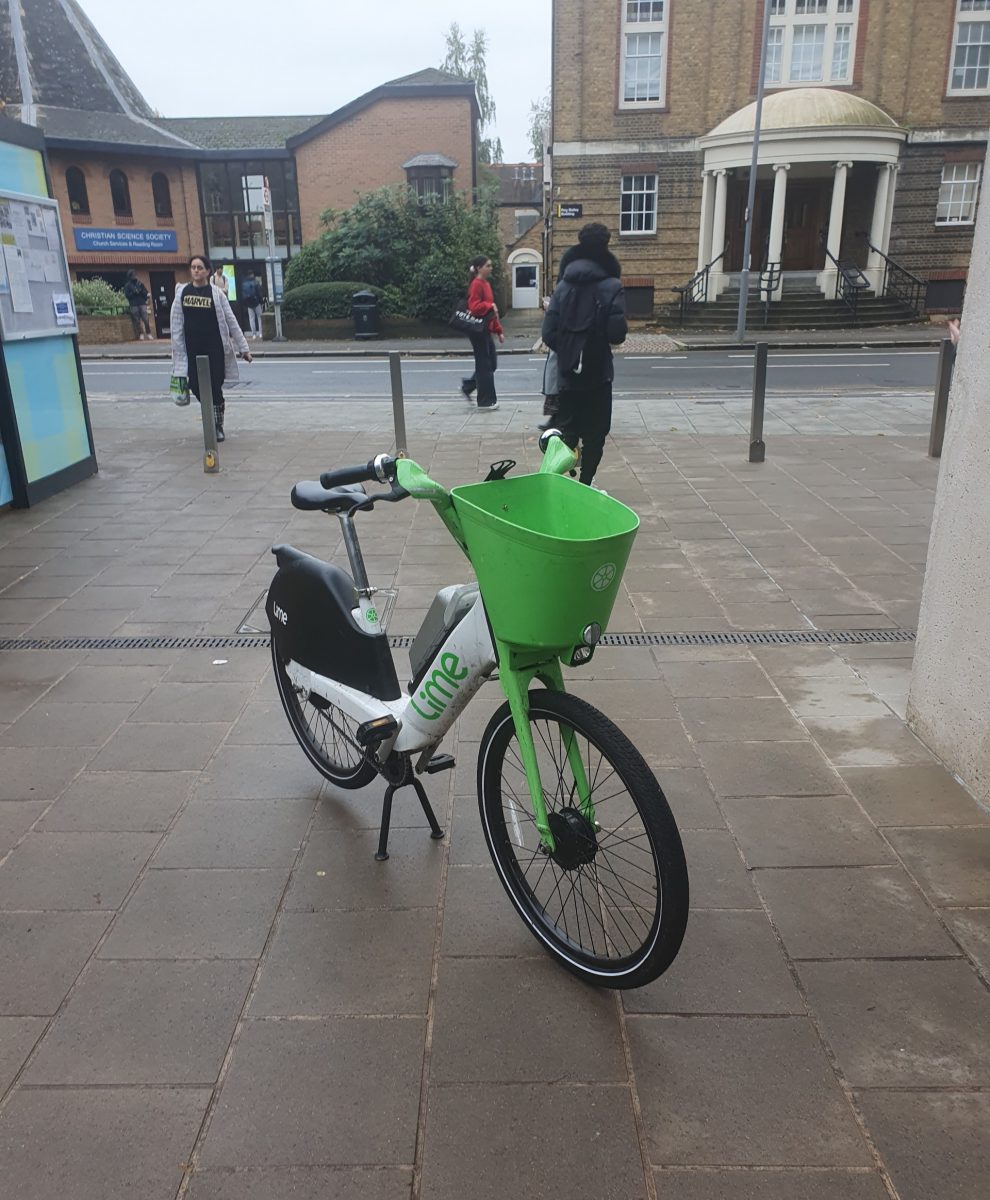 A Lime Bike parked in the middle of the pavement at Kingston University