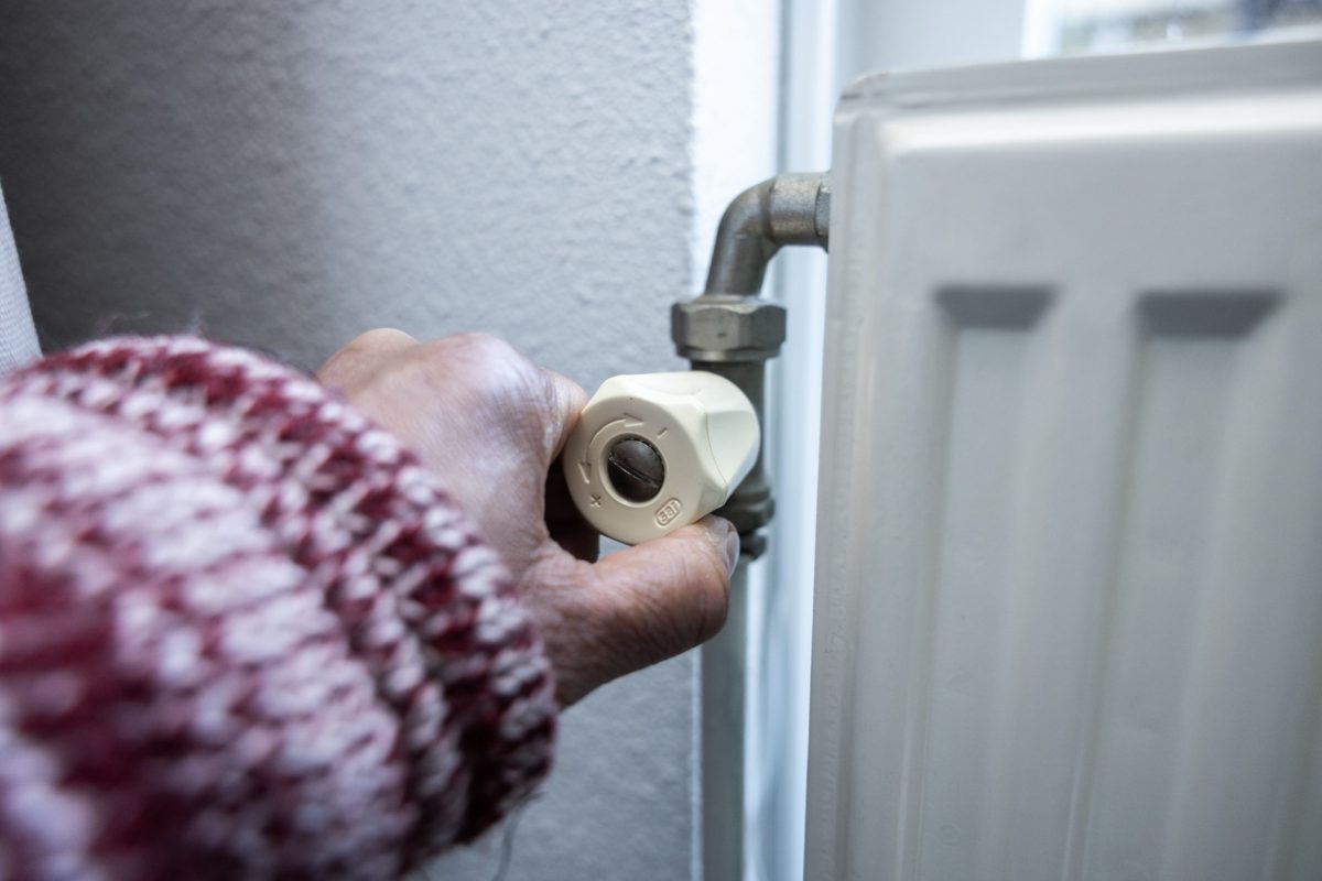 A hand turning off a radiator. 