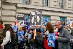 Protestors hold signs reading "Free the Gentoo Penguins, No Fresh Air Not Fair" and "Free the 15".